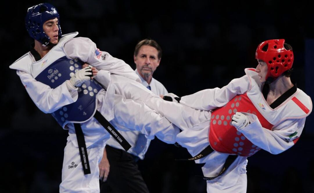 El mexicano René Lizárraga (derecha) y el estadounidense Steven López (izquierda) combaten en el último día del Campeonato Mundial de Taekwondo. FOTO/EFE