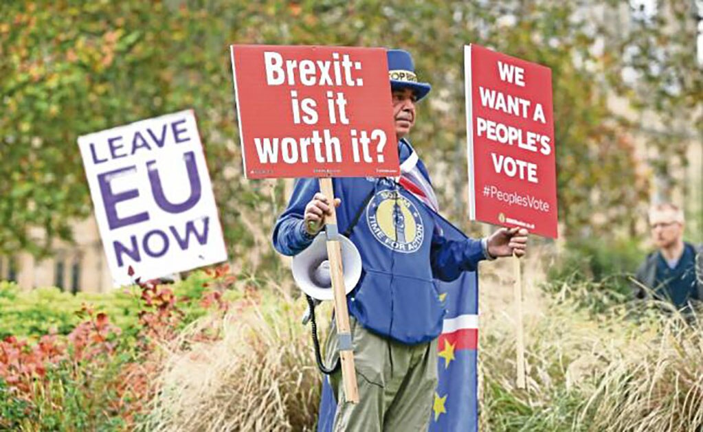 Un manifestante contrario al Brexit sostiene, en un camino en Londres, pancartas preguntándose si el proceso lo va le y demanda que los británicos voten. (DANIEL LEAL-OLIVAS. AFP)