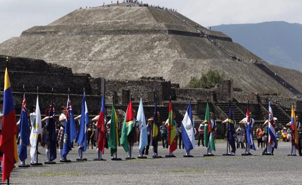 Vista de las banderas de diferentes países en Teotihuacán durante la ceremonia del fuego que enciende el pebetero, el cual viajó a Colombia para los XXIII Juegos Centroamericanos y del Caribe de Barranquilla 2018 (EFE)