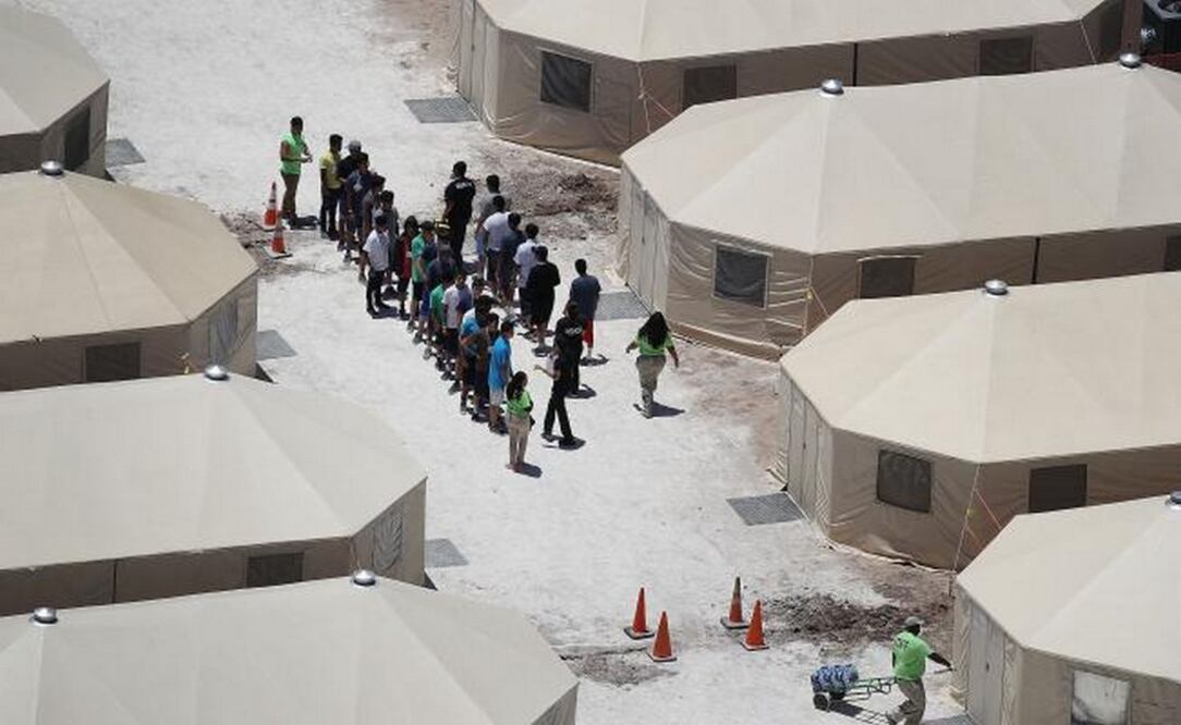 Niños migrantes y trabajadores de ICE son vistos en un campamento de tiendas de campaña construido recientemente cerca del Puerto de Entrada de Tornillo, Texas. (Foto: AFP)