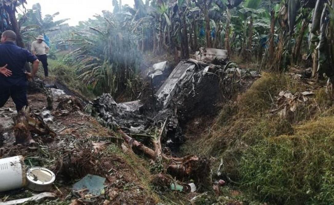 Dos hombres observan los restos de una avioneta que se accidentó este martes en una plantación bananera en la zona del Caribe de Costa Rica y que estaría ligada al narcotráfico en México. Foto: Pegando Porte y La Vara.