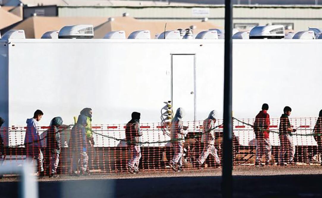 Adolescentes migrantes caminan en una fila en el centro de detención ubicado en Tornillo, Texas, el pasado 13 de diciembre. ARCHIVO. AP