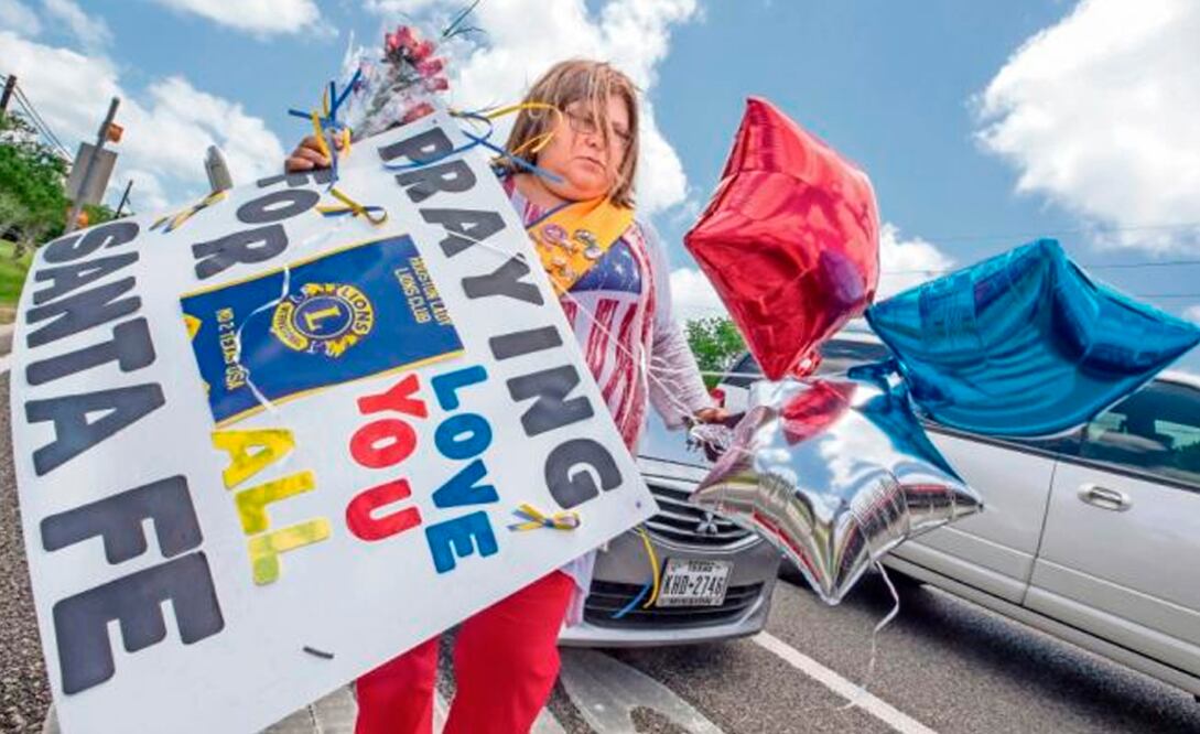 Una estadounidense carga flores y globos para colocar afuera de la secundaria Santa Fe, donde se registró el tiroteo el pasado viernes. (Foto: AP)