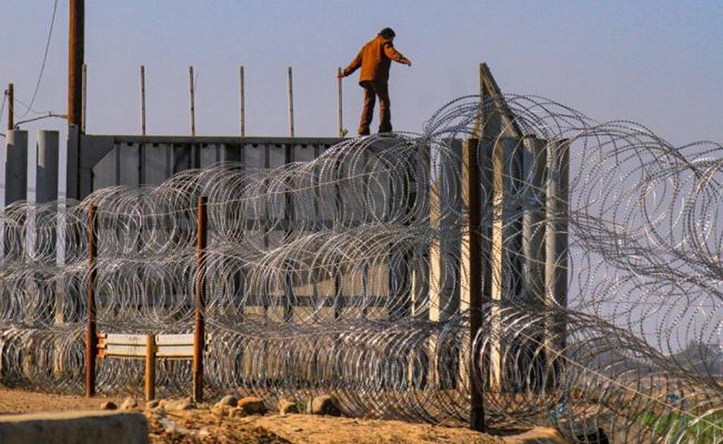 Una persona burla las alambradas de acero en Tijuana (Foto: EFE)