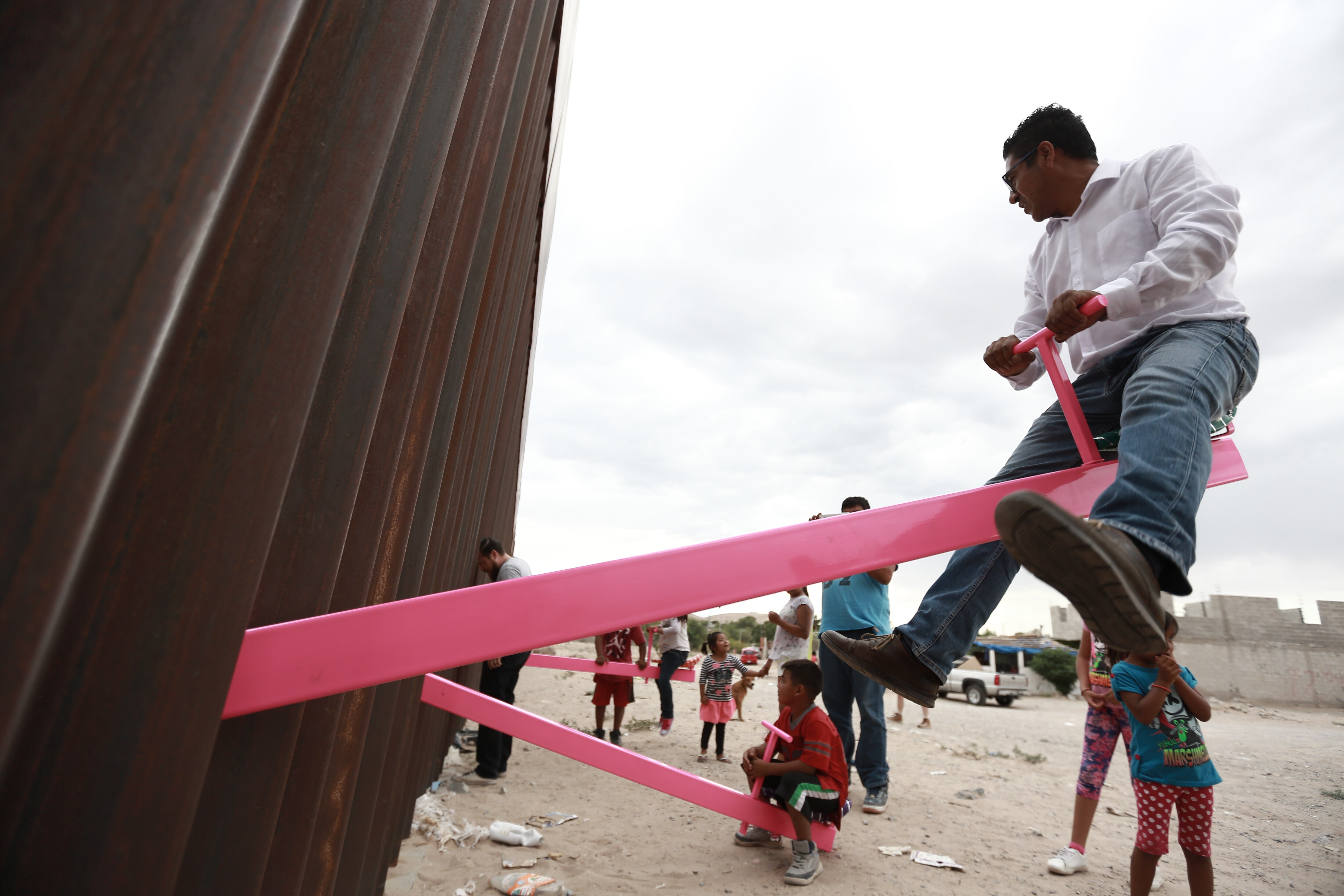 Unen a personas con un sube y baja en muro fronterizo