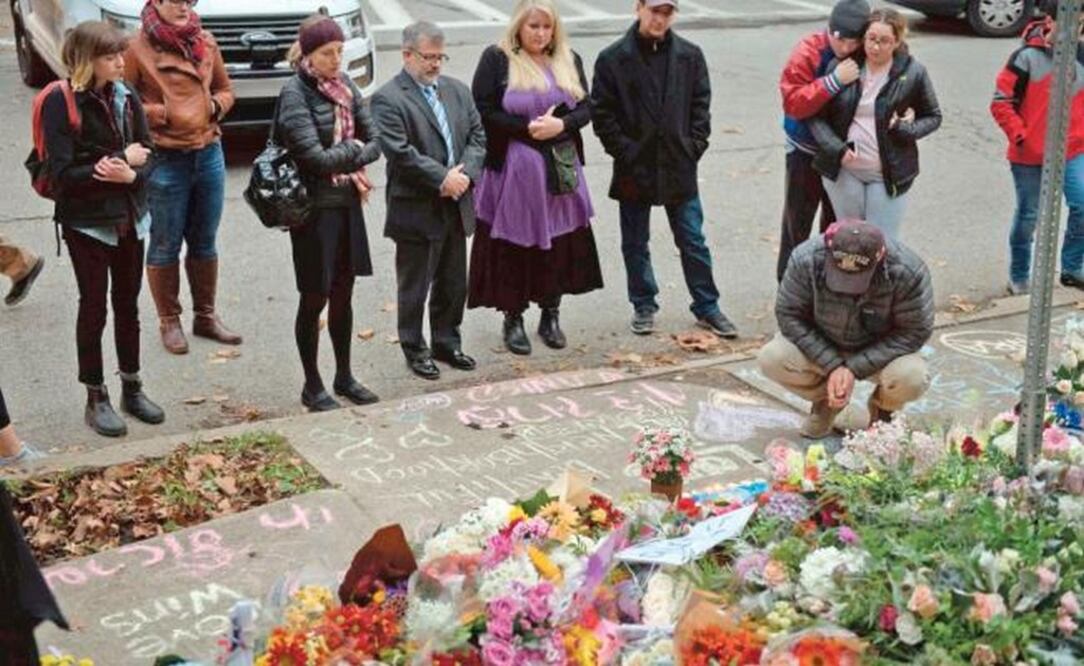 Ciudadanos de Pittsburgh dejan flores en un monumento conmemorativo a las víctimas del tiroteo masivo que mató a 11 personas en una sinagoga (JEFF SWENSEN. AFP)