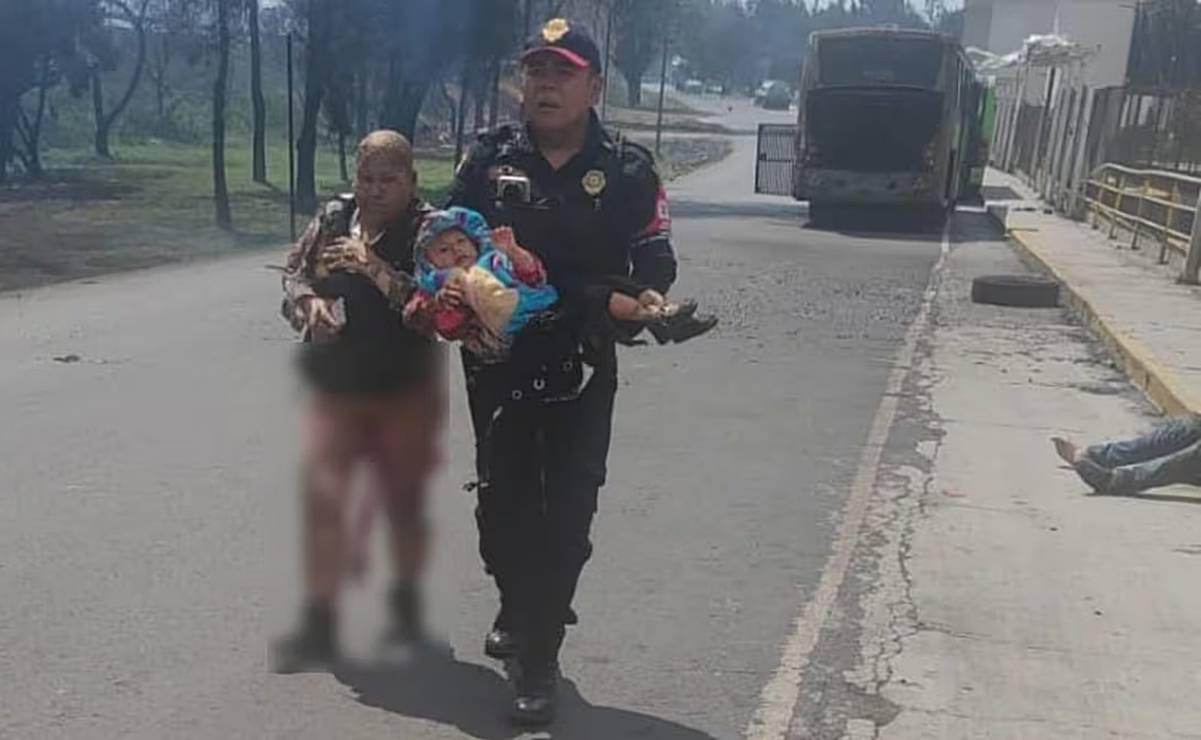 Mujer con quemaduras camina sobre el asfalto junto a policía que carga a bebé tras explosión de pipa de gas en Puente de la Concordia, Iztapalapa. (10/09/2025). Foto: Especial