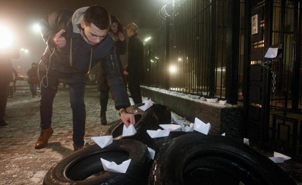 Manifestantes instalaron barcos de papel sobre los neumáticos durante su mitin cerca del edificio de la Embajada de Rusia en Kiev, Ucrania (EFE)