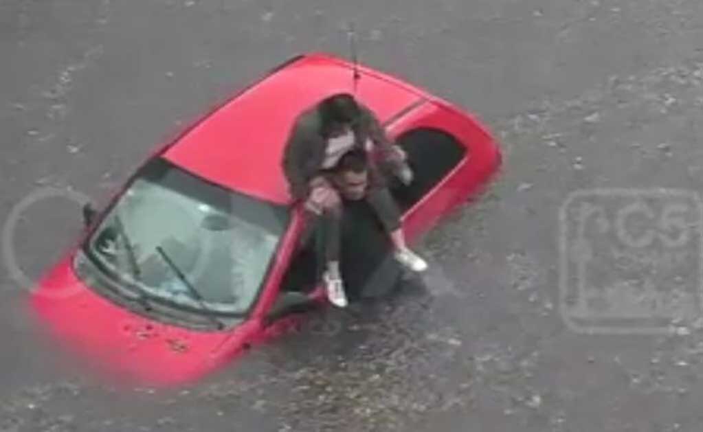 Video. Mujer se trepa a hombros de policía para salir de encharcamiento en CDMX