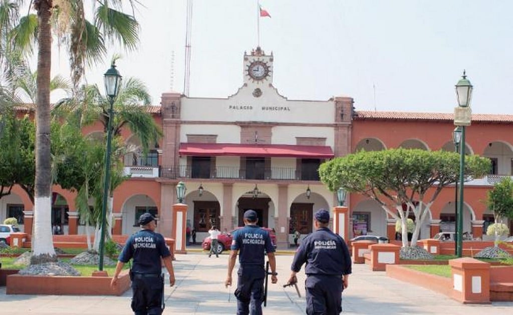 Tres elementos de la Policía Estatal en Apatzingán, Michoacán, rondan por el Palacio Municipal de esta localidad, donde la delincuencia organizada se ha disparado durante los últimos 10 años por la guerra contra el narcotráfico. Foto: ISAÍ MORALES