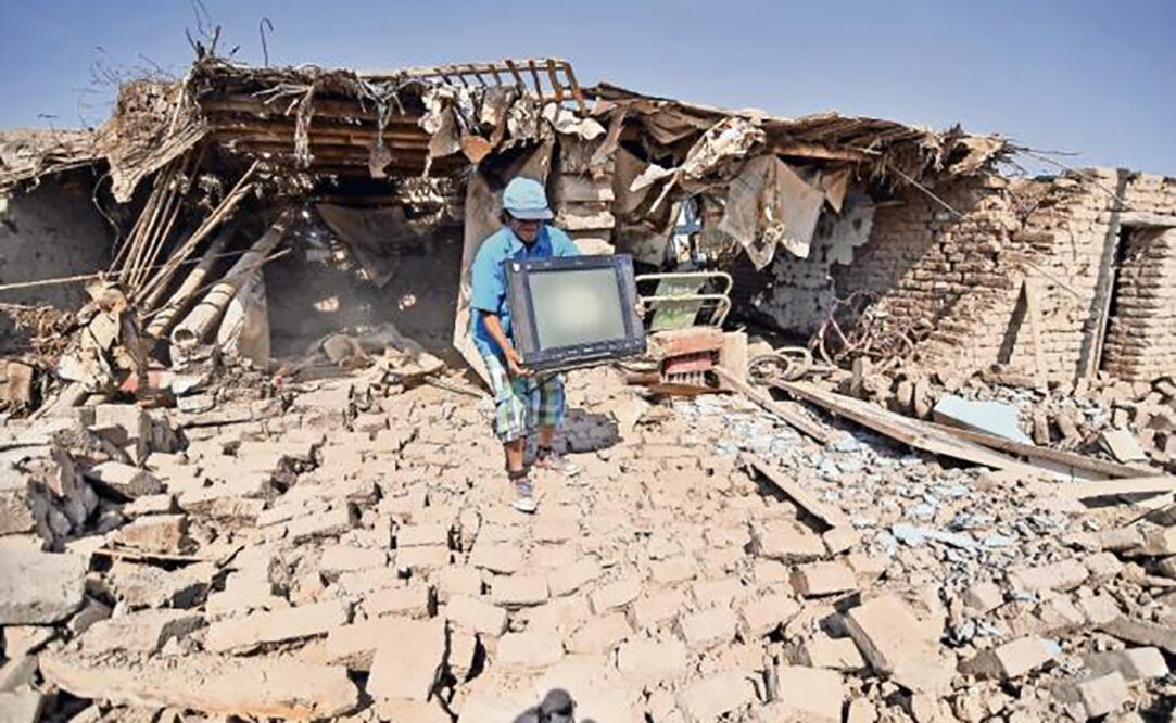 Un hombre de la localicad de Acari, en Arequipa, rescata algunas de sus pertenencias de los restos de su casa que fue destruida por el temblor que se registró ayer en el sur de Perú. (DIEGO RAMOS. REUTERS)