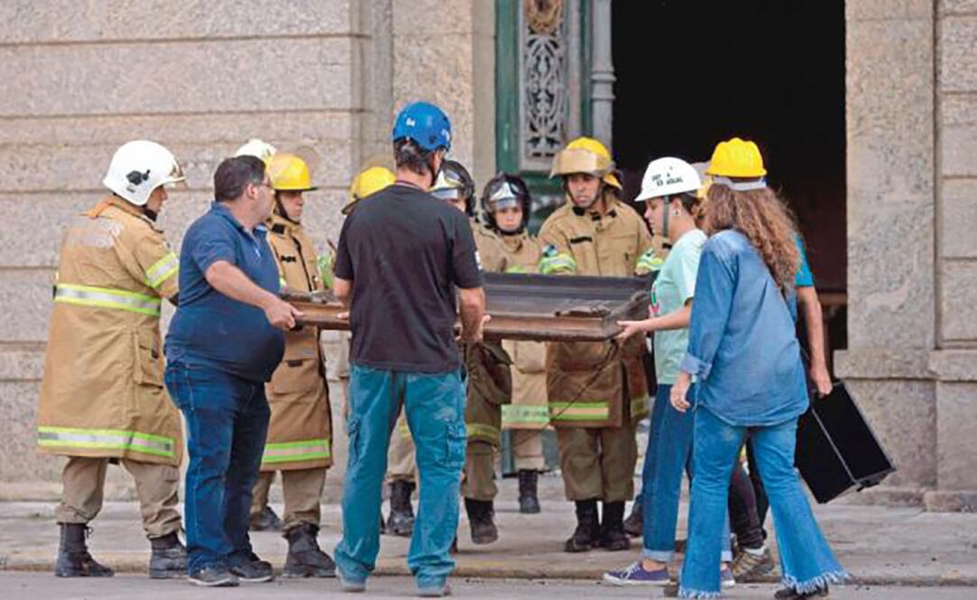 Trabajadores del museo participaron del rescate de piezas que no fueron consumidas por el fuego. (MAURO PIMENTEL. AFP)