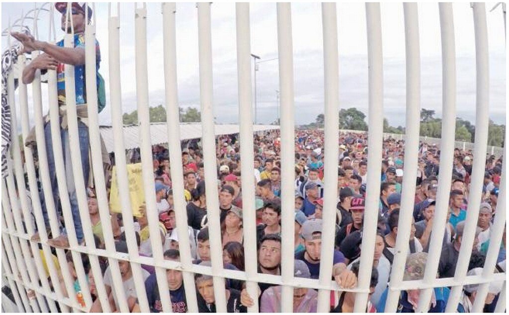 Migrantes hondureños esperaban el viernes el acceso a México, sobre el puente que atraviesa el río Suchiate en la frontera con Guatemala. MARÍA DE LA LUZ ASCENCIO. EFE