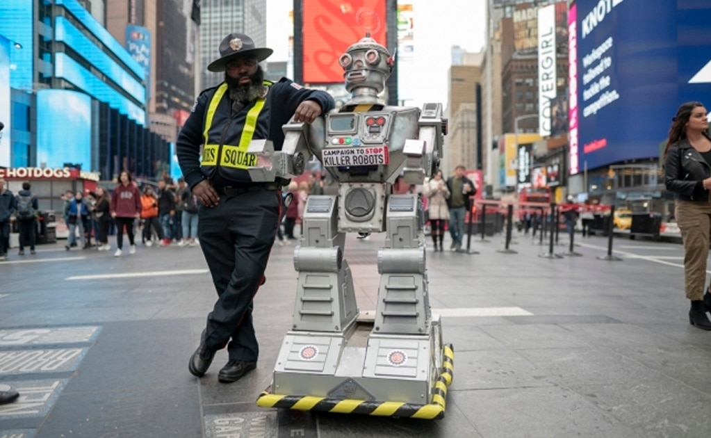 Un agente de seguridad posa junto a un robot el 20 de octubre en Times Square, Nueva York. Foto: /Campaign to Stop Killer Robots