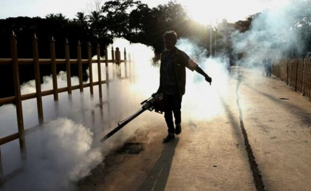 Un trabajador de la administración pública de Bangalore durante una fumigación para erradicar la amenaza de los mosquitos en el lago Ulsoor, en India. Foto: EFE