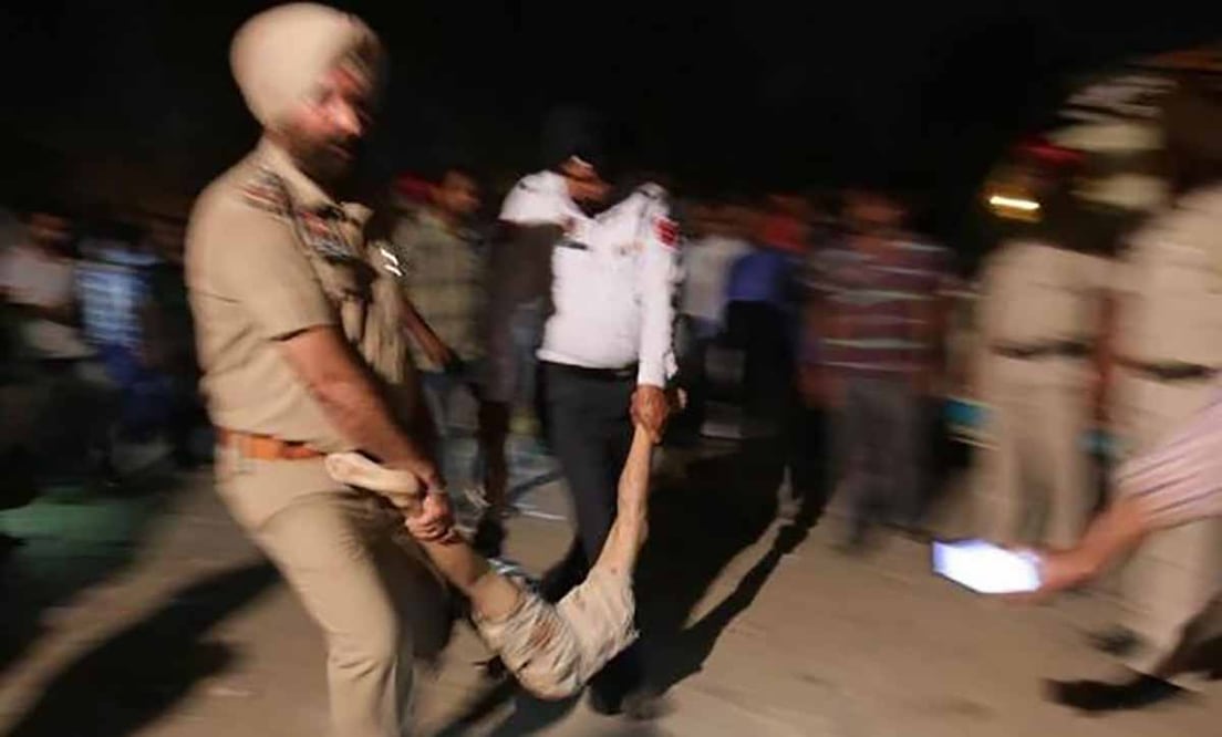 Agentes de policía transportan el cuerpo de una de las víctimas tras el accidente de tren en Amritsar (India). Foto: EFE