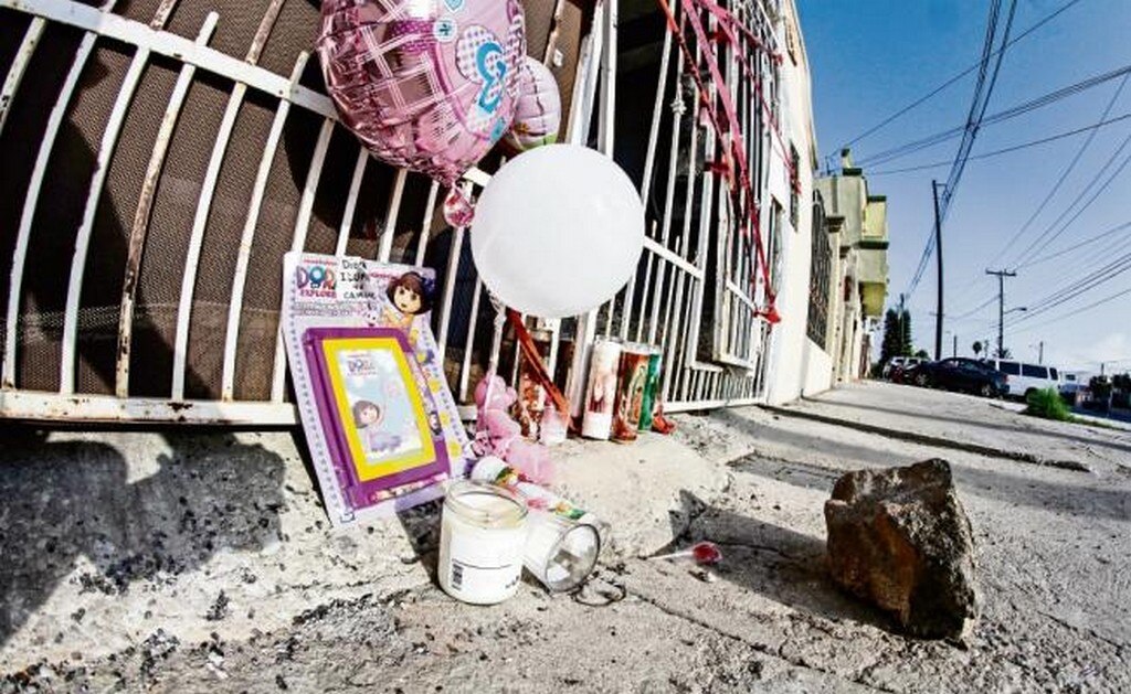 Una ofrenda fue colocada frente a un domicilio de Playas de Tijuana, donde fue hallada muerta una mujer, y su bebé, de seis meses, enterrada en el patio (ESPECIAL)