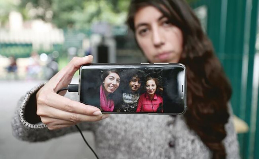 Andrea muestra la foto de su hermano Joel Sebastián Meza (al centro), alumno de la UNAM agredido el lunes pasado por porros, quienes le picaron su riñón derecho y le cercenaron una oreja. (ALEJANDRA LEYVA. EL UNIVERSAL)