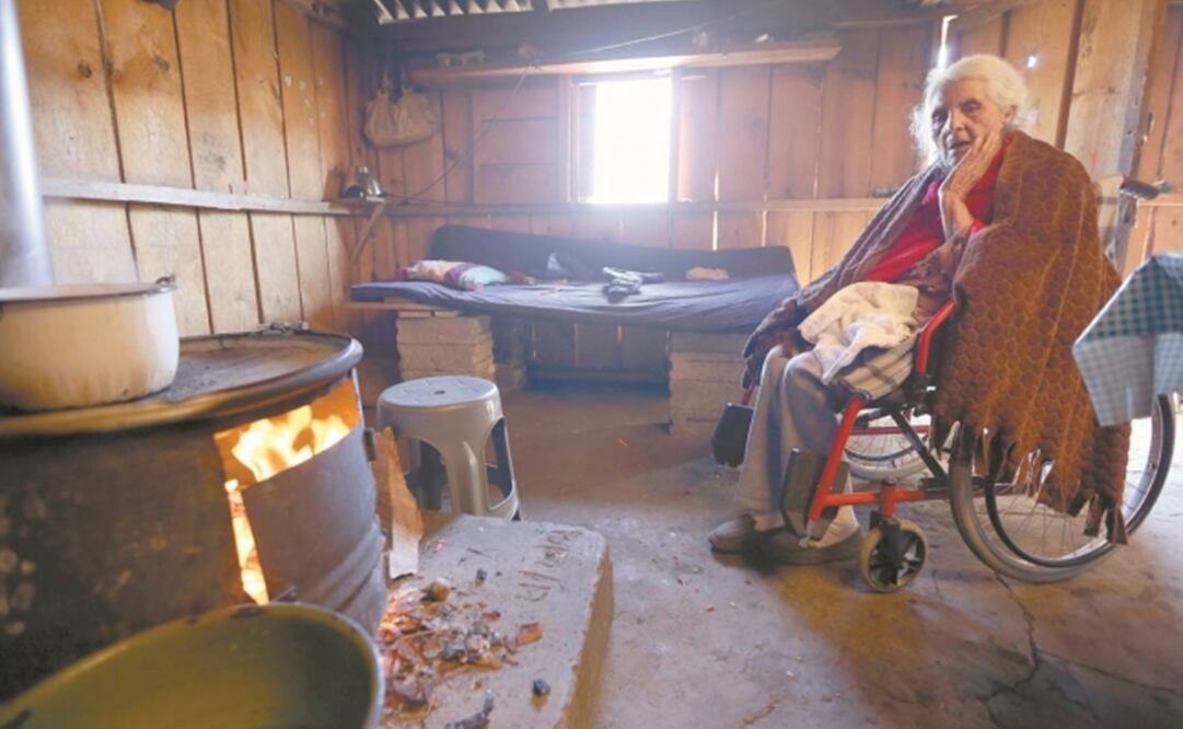 La abuela de la familia, de 90 años y en silla de ruedas, es colocada todas las mañanas por sus parientes frente a la estufa de leña por el frío. Fotos/JORGE ALVARADO. EL UNIVERSAL