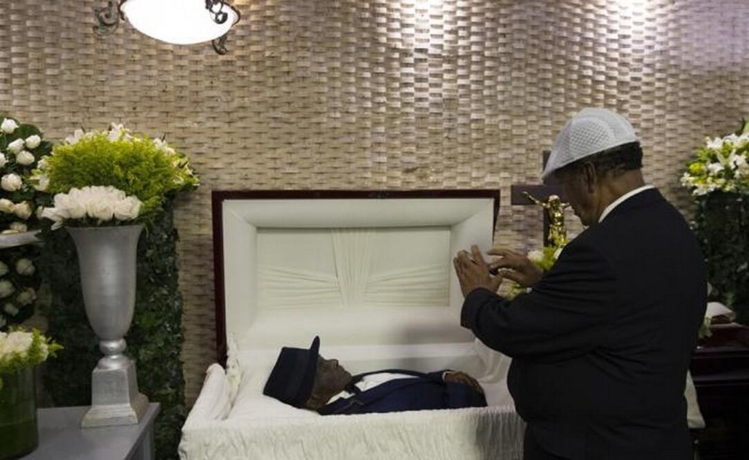 Un hombre hace una fotografía al cuerpo del cantante Joseíto Mateo, conocido como el rey del merengue. FOTO: EFE