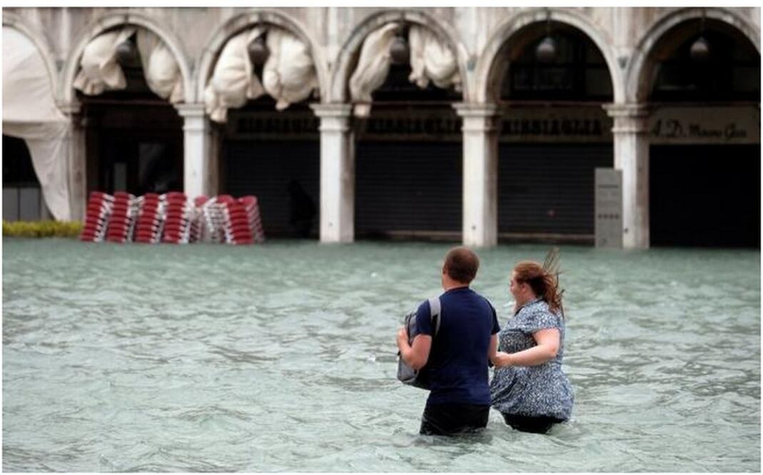 Una pareja camina sobre Saint Mark Square en Venecia tras las fuertes lluvias que provocaron inundaciones (Fotos: Reuters)