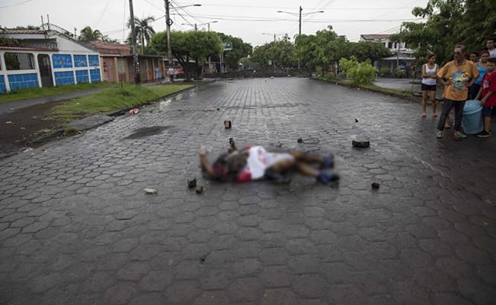 El cuerpo quemado de un hombre yace en el suelo de una calle en Managua (Foto: EFE)