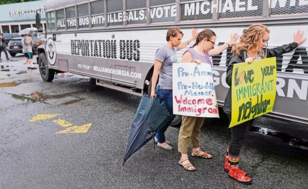 Manifestantes rodean en Clarkson el “autobús de la deportación”, del candidato republicano a la gubernatura de Georgia, Michael Williams. (ERIK S. LESSER. EFE)