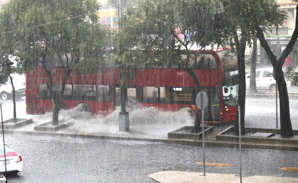 Pareja intenta cruzar desnivel inundado de plaza San Luis y su carro queda varado